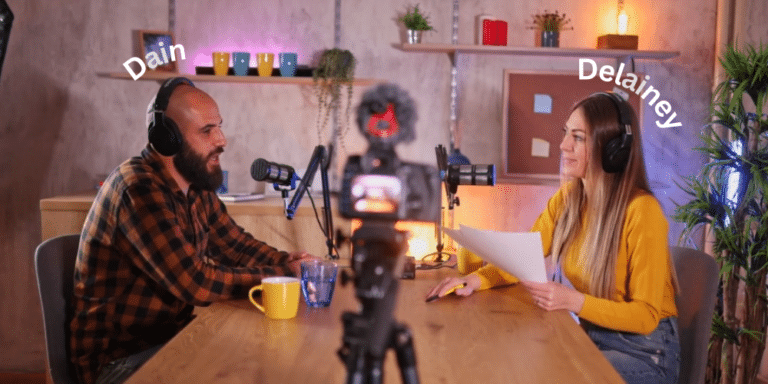 Two podcast professionals, one male - one female, seated at a table with headsets and microphones in front of them to depict Dain and Delainey