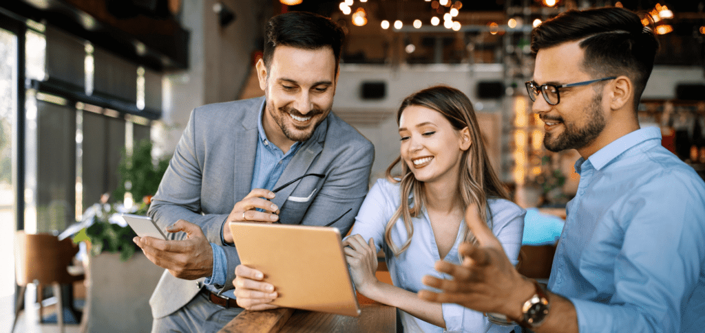 group of 3 professionals talking at papers in an office environment